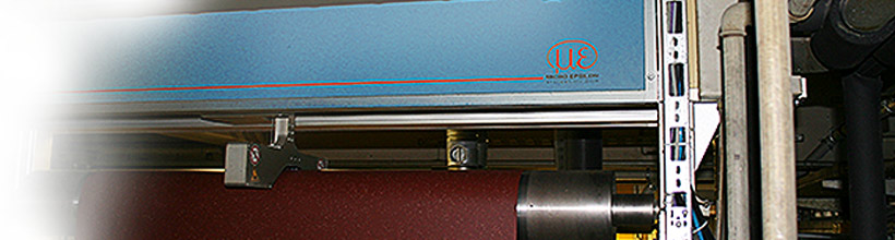 Non-contact thickness measurement in hot melt calender lines